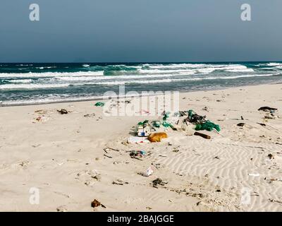 Plastikflaschen und anderer Müll, der auf die Sandküste geworfen wird, Müll am Meeresstrand, ökologisches Problem. Umweltverschmutzung. Schmutziger Sandstrände Stockfoto