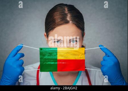 Coronavirus in Benin Female Doctor Portrait Hold Protect Face Surgical Medical mask with Benin National Flag. Krankheit, Virus Covid-19 in Benin, Schein Stockfoto