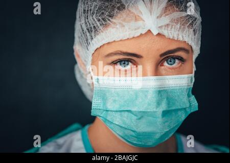 Schutz vor ansteckenden Erkrankungen, Coronavirus. Foto Im Hochformat. Medizinische Fachangestellte, die eine Gesichtsmaske, eine Kopfbedeckung und einen Anzug im Inneren des Gesichts tragen Stockfoto
