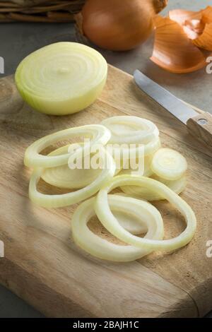 Frisch geschnittene roh braune geschälte Zwiebeln auf einem Schneidebrett Stockfoto
