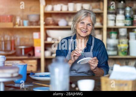 Portrait of senior female pottery artist in her art studio Stockfoto