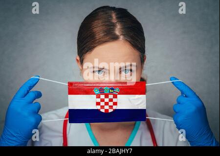 Coronavirus in Kroatien Female Doctor Portrait Hold Protect Face Surgical Medical mask with Croatia National Flag. Krankheit, Virus Covid-19 in Kroatien, Stockfoto