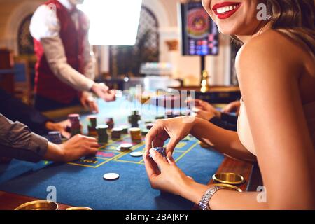 Chips in die Hände eines weiblichen Roulette Spieler im Casino Hintergrund. Stockfoto
