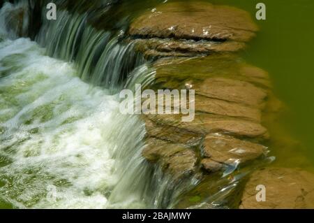 Wasser fließt in den Teich, der zentral zum städtischen Hong Kong Park auf der Insel, Hongkong SAR, China, führt Stockfoto