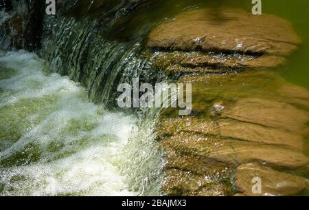 Wasser fließt in den Teich, der zentral zum städtischen Hong Kong Park auf der Insel, Hongkong SAR, China, führt Stockfoto