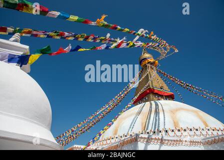 Boudha Stupa, in der Stadt Kathmandu in Nepal gegen den blauen Himmel, mit religiösen bunten Flaggen schwenkt. Stockfoto