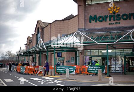 Piershill, Edinburgh, Schottland, Großbritannien. März 2020. Coronavirus Soziale Distanzierwarteschlange um den Parkplatz in Morrisons Supermarkt in Edinburgh. Die Mitarbeiter überwachen die Anzahl der Kunden im Coffee House zu einem beliebigen Zeitpunkt. Stockfoto