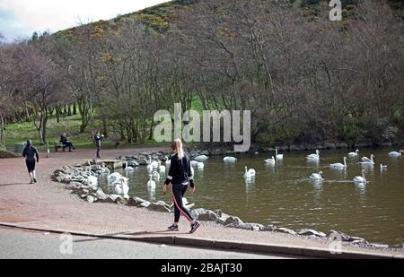 Edinburgh, Schottland, Großbritannien. März 2020. Coronavirus-Effekt, um 11 Uhr Samstag, verlassene Straßen und Tankstelle, wie ein paar Leute zum Holyrood Park gehen, um ihre erlaubte Trainingsperiode zu erhalten, aber einen sicheren Abstand voneinander zu halten. Stockfoto