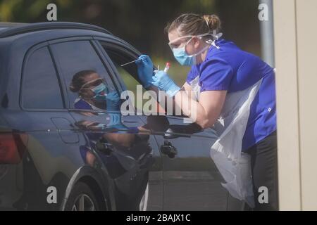 Ein NHS-Mitarbeiter, der auf Coronavirus bei einer temporären Fahrt durch die Teststation im Parkplatz von Chessington World of Adventures in Chessington, Greater London, getestet wird. Stockfoto