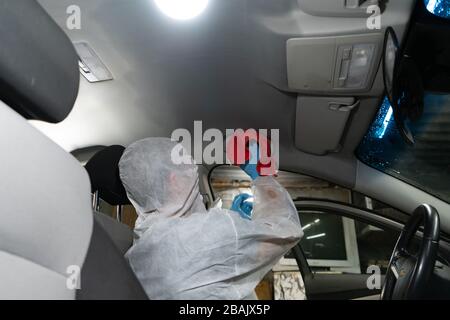Chemische Reinigung des Autos. Der Arbeiter desinfiziert mit einem Staubsauger in einem Auto Stockfoto