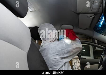 Chemische Reinigung des Autos. Der Arbeiter desinfiziert mit einem Staubsauger in einem Auto Stockfoto