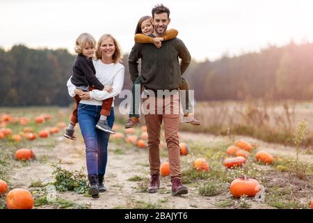 Fröhliche junge Familie im Kürbisfeld Stockfoto