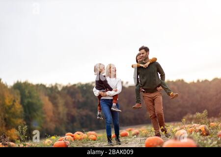 Fröhliche junge Familie im Kürbisfeld Stockfoto