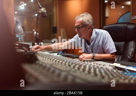 Reifer Mann am Mischpult in einem Tonstudio Stockfoto