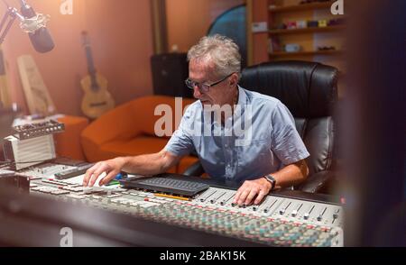 Reifer Mann am Mischpult in einem Tonstudio Stockfoto