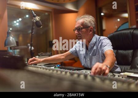 Reifer Mann am Mischpult in einem Tonstudio Stockfoto