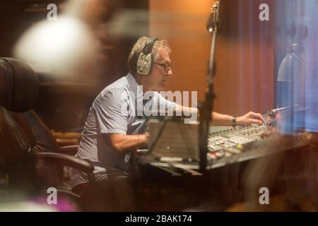 Reifer Mann am Mischpult in einem Tonstudio Stockfoto