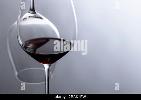 Glas Rotwein auf schwarzem, reflektierendem Hintergrund. Selektiver Fokus. Kopierbereich. Stockfoto