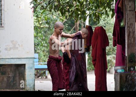 Junge buddhistische Mönch, die vor dem Mittagessen im Mahagandayon-Kloster Mandalay in Myanmar duschen Stockfoto