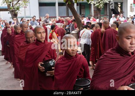 Während des weltweit größten Mittags buddhistischer Mönch im Mahagandayon-Kloster Mandalay, Myanmar, stehen junge Mönch in Schlange Stockfoto