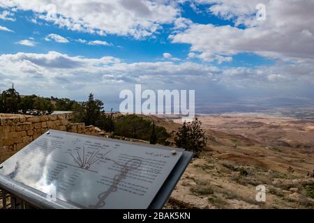 MADABA, JORDANIEN - 1. FEBRUAR 2020: Blick auf die Landschaft, Landschaft mit Infoplatte, gelobtes Land und Totes Meer vom Berg Nebo, Königreich Jordanien, Naher Osten, schöne Wolken winder Winternachmittag Stockfoto