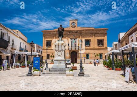 FAVIGNANA, ITALIEN - 16. JUNI 2019: Das Rathaus und die Statue der Florio auf dem Hauptplatz von Favignana, Aegadische Inseln, Sizilien Stockfoto