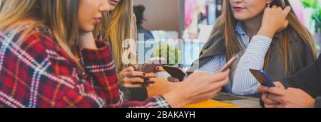 Eine Gruppe von Freunden, die mit ihren Mobiltelefonen in einer Bar sitzen - junge Leute, tausende von Festnetztelefonen, die Onli genießen Stockfoto