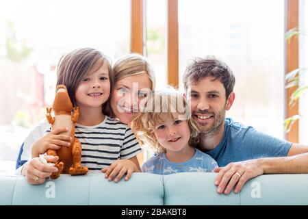 Glückliche junge Familie mit zwei Kindern zu Hause Stockfoto