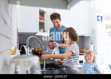 Kinder helfen Vater in der Küche Stockfoto