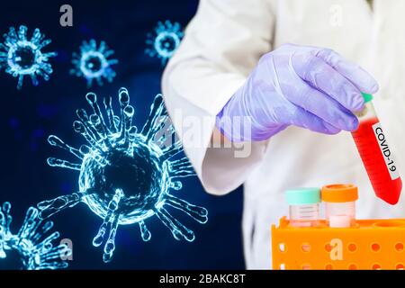 Mikrobiologe mit einem von Coronavirus verunreinigten Röhrchen biologischer Probe mit dem Etikett Covid-19 im Labor. Stockfoto