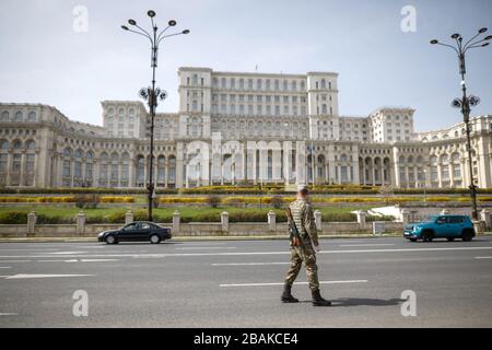 Bukarest, Rumänien - 28. März 2020: Rumänischer Armeesoldat vor dem Palast des Parlaments, um eine Ganztagssperrung durchzusetzen, um die Ausbreitung von zu begrenzen Stockfoto
