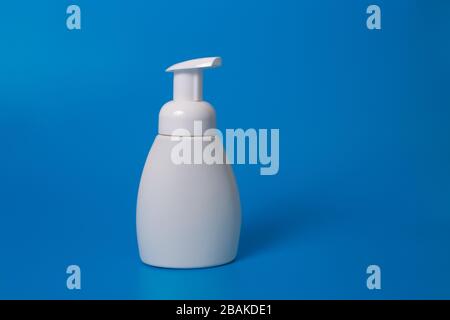 Weiße Flasche Flüssigseife auf blauem Hintergrund. Kopierbereich. Verspotten Sie sich Stockfoto