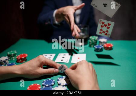 Professionelles Pokerspiel. Pokertisch mit zwei Spielen. Pokerspieler faltet, indem er Karten auf den Tisch wirft Stockfoto