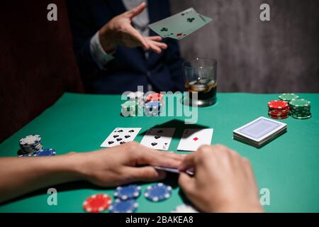 Professionelles Pokerspiel. Pokertisch mit zwei Spielen. Pokerspieler faltet, indem er Karten auf den Tisch wirft Stockfoto