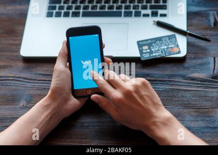 Wunsch-App in einem Smartphone geöffnet, android-Gerät über dem Tisch, weißer Hintergrund Stockfoto
