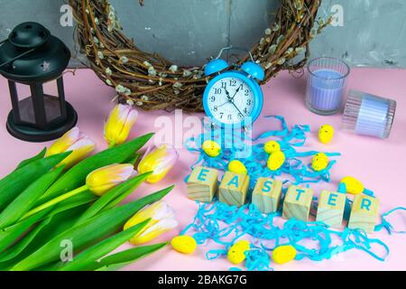 Wort Ostern auf Holzwürfeln und umgeben mit mehreren Eierdekorationen als festliche Oster-Hintergrundkomposition Stockfoto