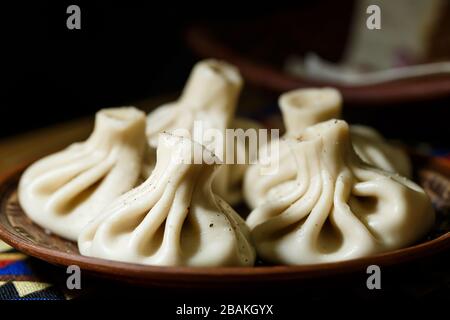 Georgisches Nationalgericht Khinkali. Auf eine Tonplatte gelegt Stockfoto