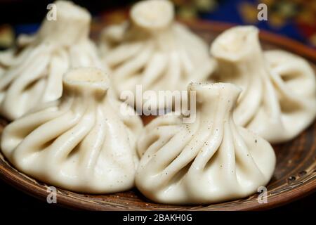 Georgisches Nationalgericht Khinkali. Auf eine Tonplatte gelegt Stockfoto