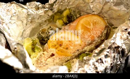 Gesunde Ernährung. Forelle in Folie mit Brokkoli und Zitronen gebacken Stockfoto