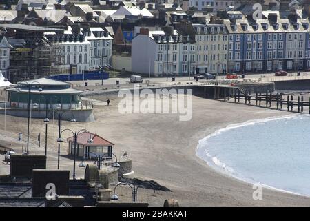 Aberystwyth Wales UK Covid-19 Lockdown 28. März 2020. Ein heller und sonniger Samstagnachmittag und die Küstenstadt Aberystwyth sind weitgehend verlassen, wobei die meisten Menschen die erzwungene Aussperrung der Regierung aufgrund des Coronavirus, Covid-19-Ausbruchs beobachten. Diejenigen, die an einem schönen Frühlingstag rund um die walisische Küste trainieren, nehmen sich Zeit, an der normalerweise geschäftigen Strandpromenade und am Strand zu trainieren. Kredit: mike davies/Alamy Live News Stockfoto