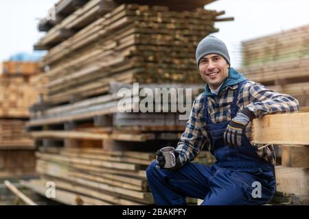 Junger männlicher Arbeiter im Holzlager Stockfoto