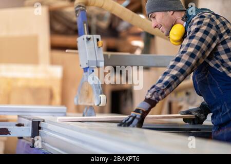Junger männlicher Arbeiter im Holzlager Stockfoto