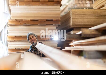 Junger männlicher Arbeiter im Holzlager Stockfoto