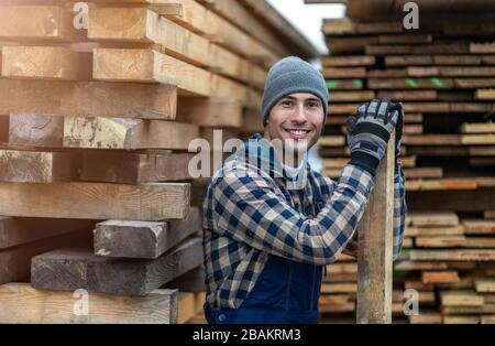 Junger männlicher Arbeiter im Holzlager Stockfoto