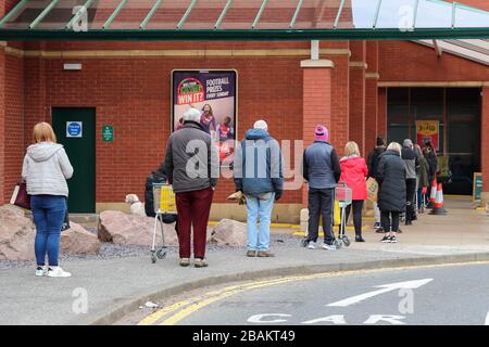 Ayr, Großbritannien. März 2020. Gemäß den Anweisungen der Regierung bleiben die meisten Menschen fern von den normalerweise beliebten und geschäftigen Einkaufszentren und Straßen von Ayr, die ein fast leeres Stadtzentrum mit Ausnahme einiger Lebensmittelhändler und Apotheken verlassen. Der Kunde steht in einer geordneten Warteschlange, hält 2 Meter auseinander und wartet darauf, im Morrisons Supermarkt Ayr einkaufen zu dürfen. Credit: Findlay/Alamy Live News Stockfoto