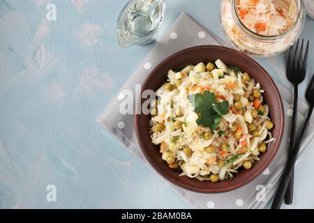 Gesunder Salat aus Sauerkraut, Erbsen und Karotten in einer Schüssel auf hellblauem Grund, Copy Space Stockfoto