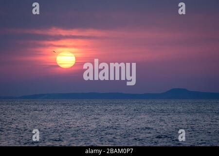 Sonne, die über den Kurileninseln, Russland, Tapete, Blick von Hokkaido, Japan, schöne Morgenaufgangsszene, Sonne über ruhigem Ozean, romantischer Mystiker sc Stockfoto