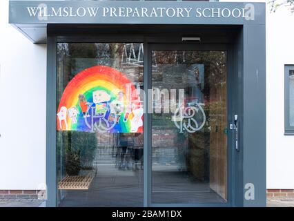 Rainbow entwirft symbolischen Coronavirus Lockdown und bleibt in Großbritannien zu Hause. Dieses Bild im Fenster einer Prep School in Wilmslow, Cheshire, UK 28.03 Stockfoto