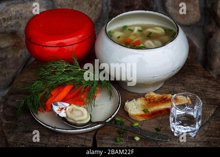Suppe mit Knödel und Wodka auf einem Holztisch Stockfoto