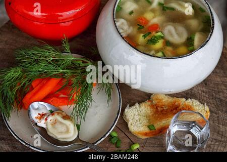 Suppe mit Knödel und Wodka auf einem Holztisch Stockfoto